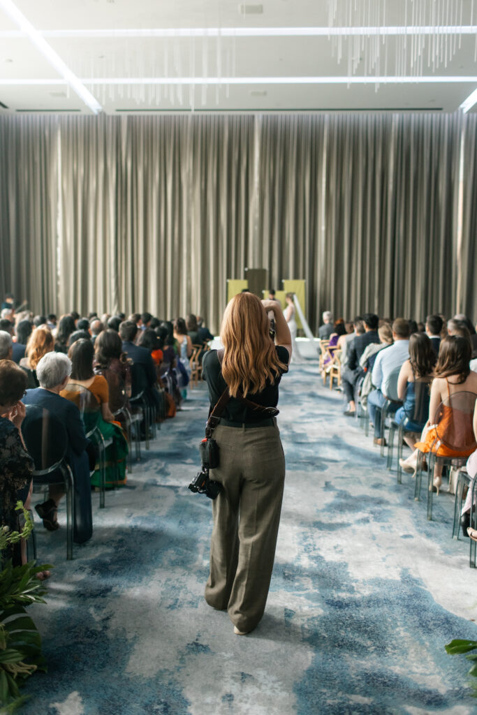 A wedding photographer stands in the aisle to capture the ceremony at the JW Marriott Ice District in Edmonton